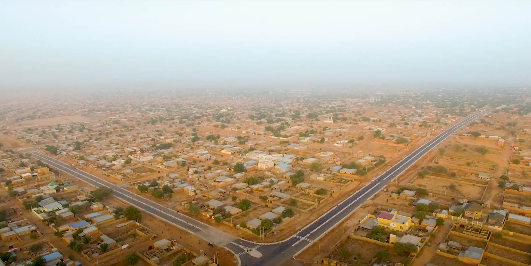 Vue aérienne de Zinder, ses quartiers et une route qui traverse la ville